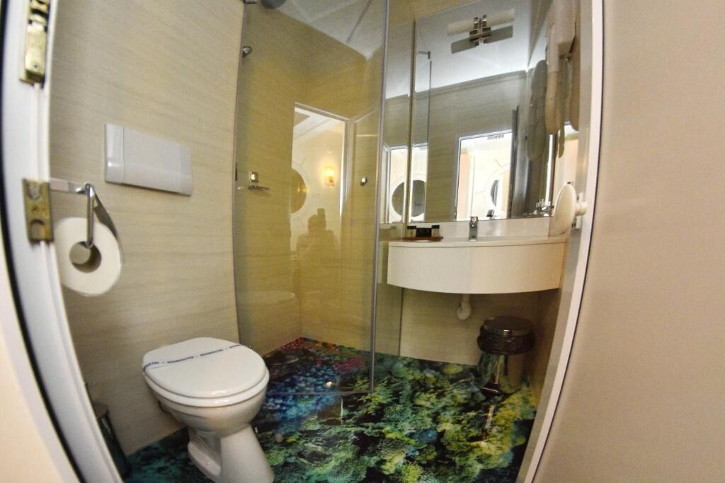 A bathroom with a toilet, a sink, and a mirror.