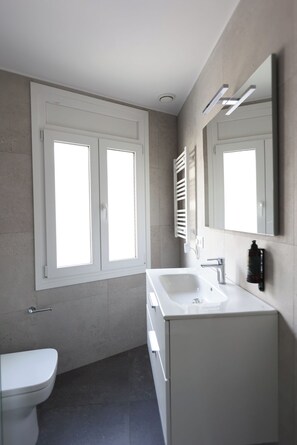 A modern bathroom with a toilet, a sink, and a mirror. - Telecabine365 (La Massana)