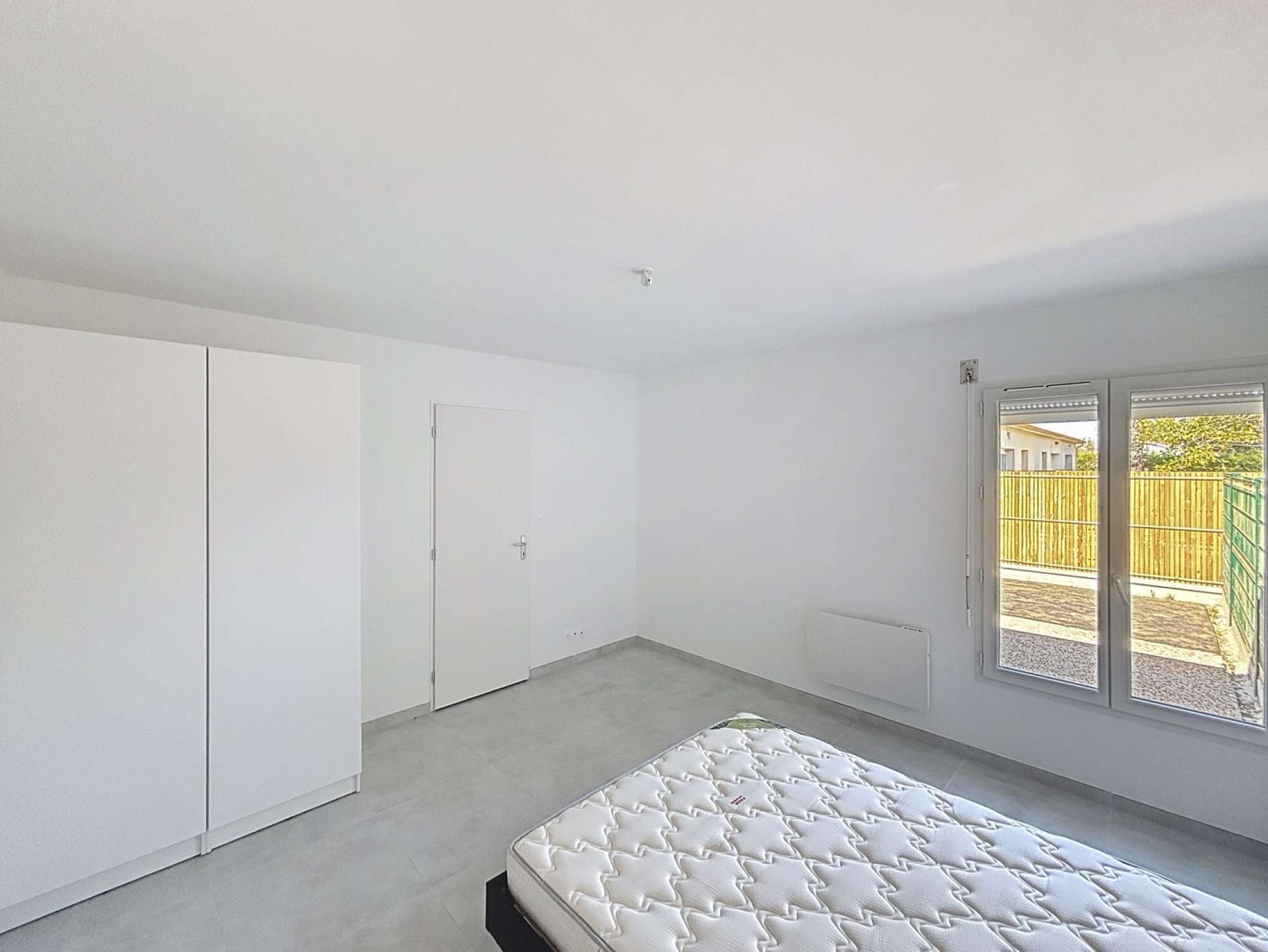 A bedroom with a bed, a wardrobe, and a door.
