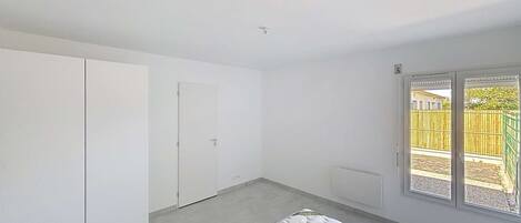 A bedroom with a bed, a wardrobe, and a door.