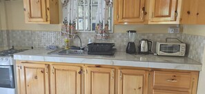 Een koelkast, een oven, een kookplaat, een waterkoker