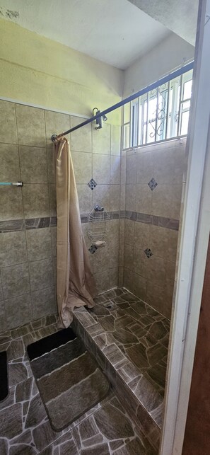 Een douche, handdoeken, zeep, toiletpapier