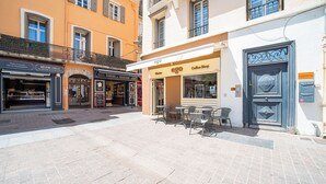 A street with cafes and shops, outdoor seating, and a blue door. - Urban Getaway: Maillol Suite in the Center with Free Wifi (Perpignan)