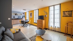 Ein modernes Wohnzimmer mit Sofa, Couchtisch und Essbereich.