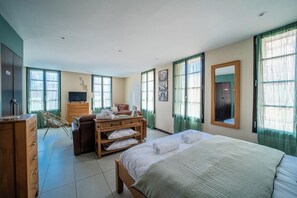 A hotel room with a bed, a wooden dresser, a television, and a desk. - Suite Majorca Downtown Free WiFi (Perpignan)