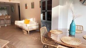 A dining area with a round table, woven placemats, and wicker chairs. - Charming Collioure • Terrace • Parking • Wi-Fi (Collioure)