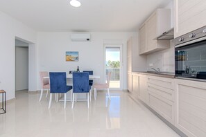 Familienapartment, eingeschränkter Meerblick | Essbereich im Zimmer