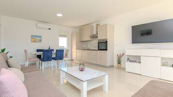 Family Apartment, Partial Sea View | Living area | 100-cm flat-screen TV with satellite channels