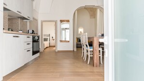 Una cocina moderna con armarios blancos y una mesa de comedor de madera con sillas.