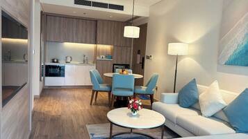 A modern living room with a sofa, coffee table, and dining area with chairs.