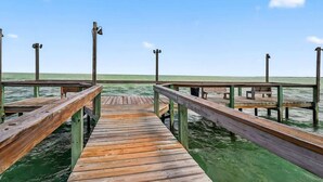 Eine Holzstege, der sich ins ruhige Wasser erstreckt, mit Bänken und einer Geländer.