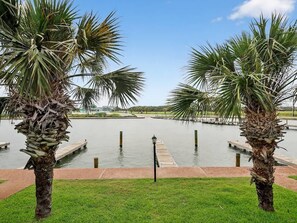 A water body with palm trees and a dock.