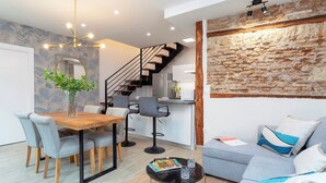Ein modernes Wohnzimmer mit Essbereich, Treppe und Küche.