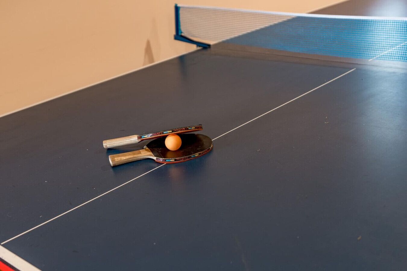 A table tennis table with a paddle and ball.