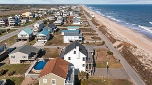 A coastal residential area with houses, a beach, and a road. - Summer Winds #191 - Ocean Views, Hot Tub & Steps to the Beach! Dog Friendly! (North Topsail Beach)