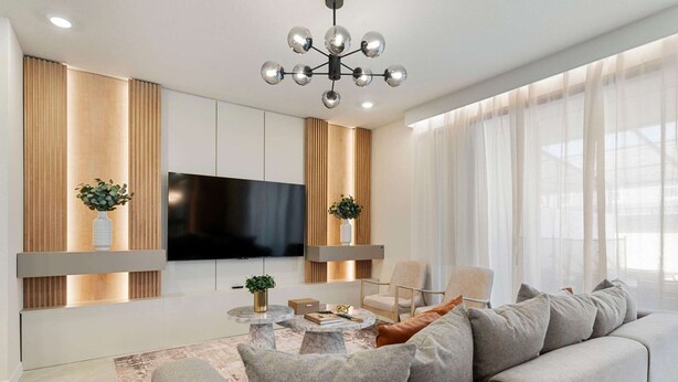 A modern living room with a sofa, coffee table, TV, and decorative plants. - 1149 Spacious Family 5-bedroom Townhome (Clermont)