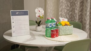 A table with a menu, green water bottles, a Coca-Cola can, and a basket with snacks.