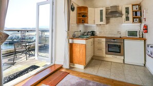 Una cucina moderna con vista all'esterno, armadietti in legno, un forno a microonde e un piccolo forno.