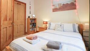 Una camera da letto con un letto grande, un'armadiatura in legno, delle librerie e un quadro appeso al muro.
