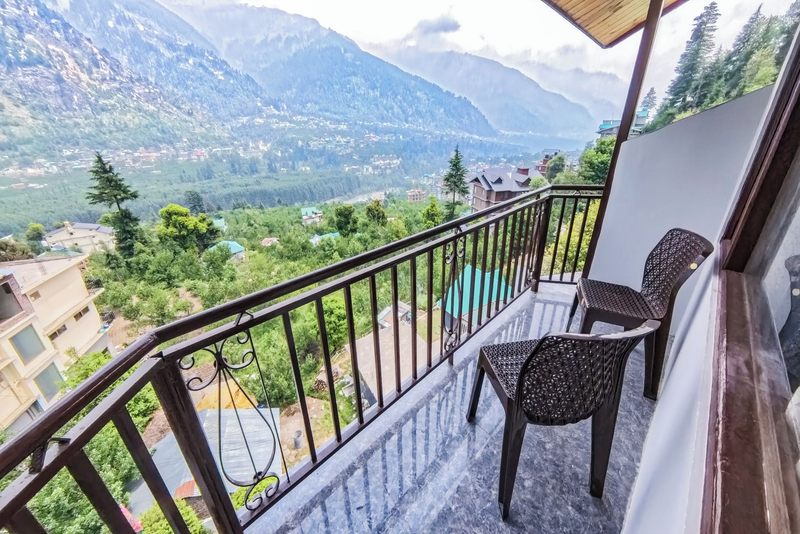 Un balcón con vistas a montañas y una piscina.