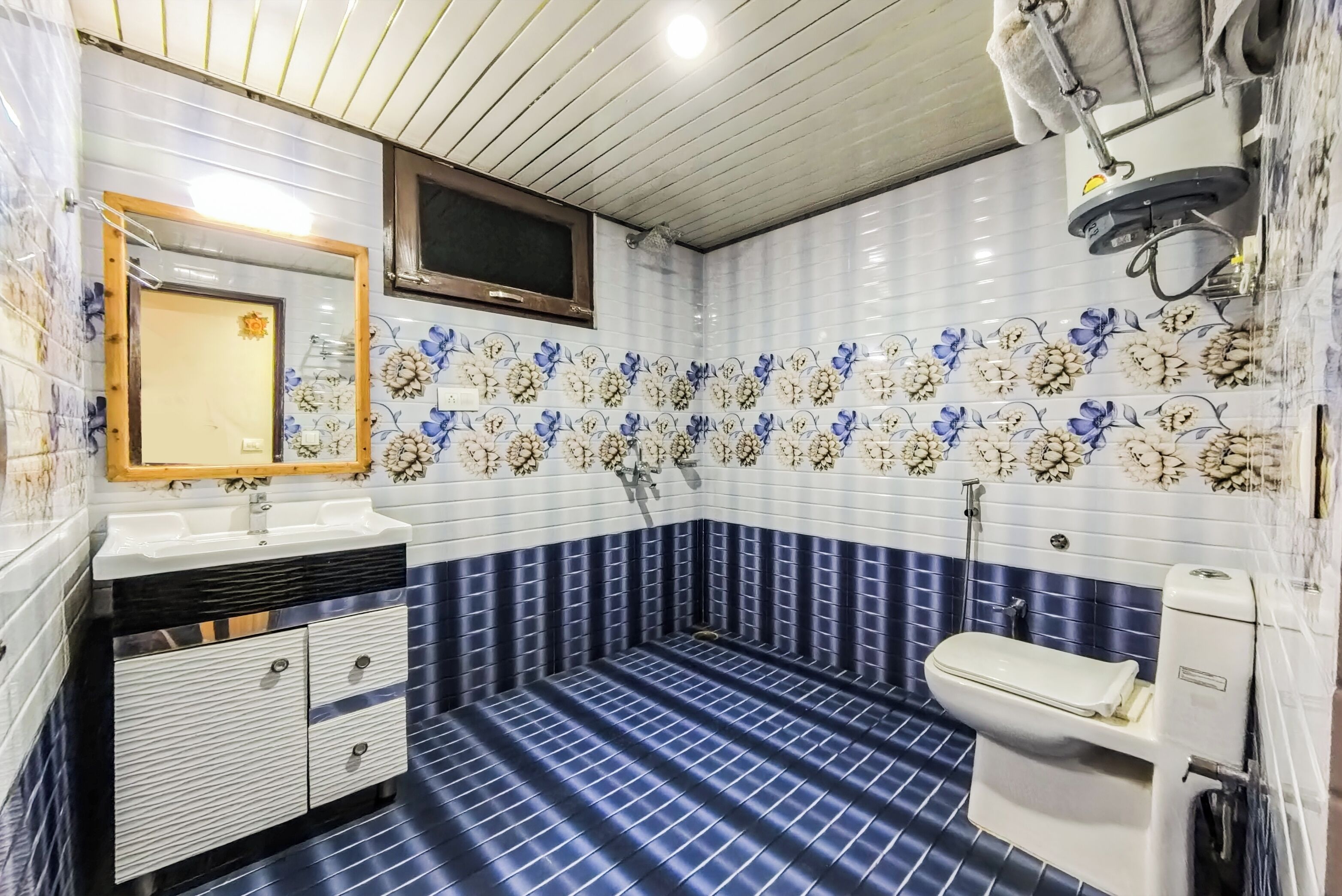 A bathroom with a tiled floor, a sink, a toilet, and a mirror.