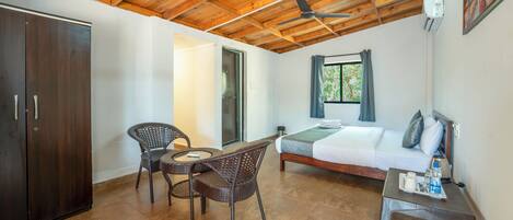 Una stanza con un letto, un tavolo con vassoio, un armadio e una ventola a soffitto.