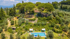 A large, rectangular swimming pool surrounded by lush greenery and trees, with a small gazebo and a few outdoor seating areas. - Relaxing Tuscan Terrazza Near Florence 4shared Pool (Impruneta)