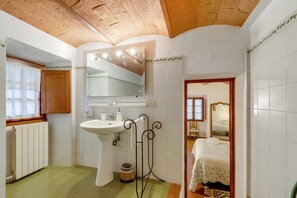 Un baño con lavabo, espejo y radiador.
