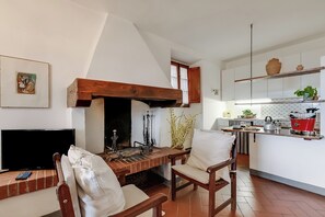 A cozy living room with a fireplace, a television, and a dining area with chairs. - Relaxing Tuscan Terrazza Near Florence (Impruneta)