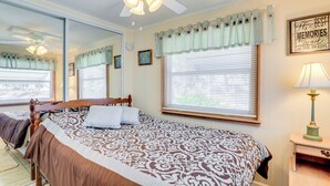 A bedroom with a large bed, a ceiling fan, a window with blinds, a bedside lamp, and a mirror. - 2 Mi to Venice Beach: Home w/ Pool Access (Venice)