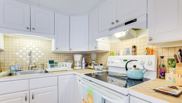 A kitchen with white cabinets, a stove, and a sink. - 2 Mi to Venice Beach: Home w/ Pool Access (Venice)