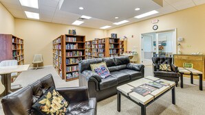 A library with leather furniture, bookshelves, and a clock on the wall. - 2 Mi to Venice Beach: Home w/ Pool Access (Venice)