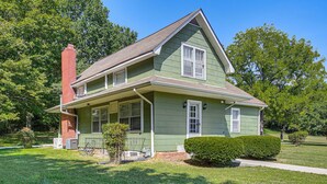 A two-story house with a green exterior, a brick chimney, and a well-maintained lawn. - 4 Mi to Dtwn: Goodlettsville Getaway w/ Yard (Goodlettsville)