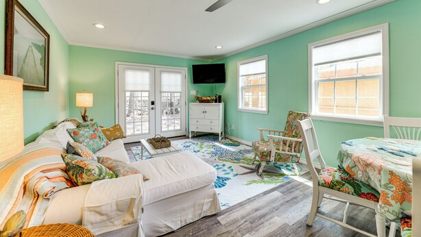 A room with a sofa, a chair, a table, and a ceiling fan. - Walk to Pier & Dining: Central Rockport Cottage (Rockport)