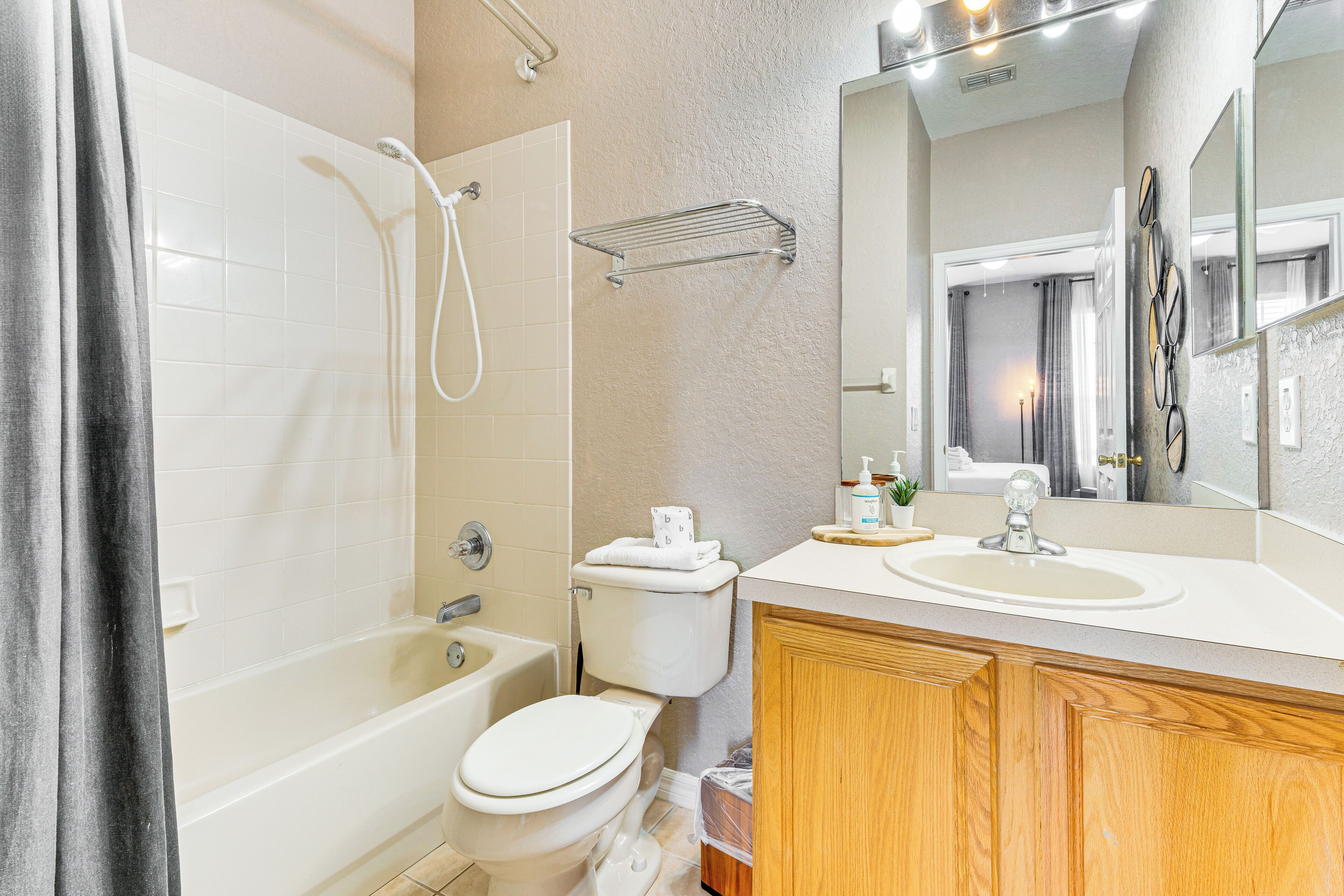Une salle de bain moderne équipée d’une baignoire, de toilettes et d’un meuble-lavabo avec un miroir.