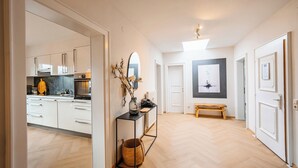 Eine moderne Küche mit weißen Schränken, Holzboden und einer Essecke mit einer Bank.