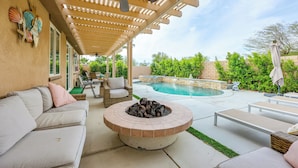 A covered outdoor patio with a fire pit, lounge chairs, and a pool. - Gazebo + Putting Green: Serene Indio Getaway (Indio)