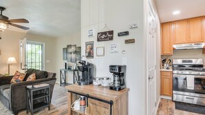 Una cucina moderna con mobili in legno, un forno in acciaio inossidabile e un angolo caffè.