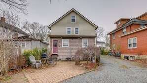 A two-story house with a brick patio, a red door, and a small garden area. - Walkable Dtwn Townhome Near Campus & Palmer Square (Princeton)