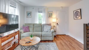A living room with a sofa, a coffee table, a TV, and a lamp. - Walkable Dtwn Townhome Near Campus & Palmer Square (Princeton)