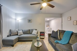 A living room with a sectional sofa, a coffee table, and a ceiling fan.