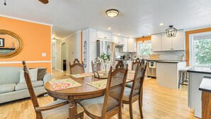 A dining area with a round table, wooden chairs, and a patterned table runner. - Walk to Lake Huron Beaches: Home w/ Fire Pit! (Rogers City)