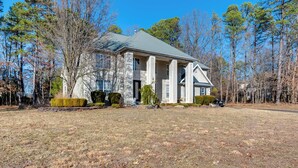 A large, stately house with a prominent entrance, large windows, and a well-maintained lawn. - Theater & Game Room at Trenton Area Home (Jackson)