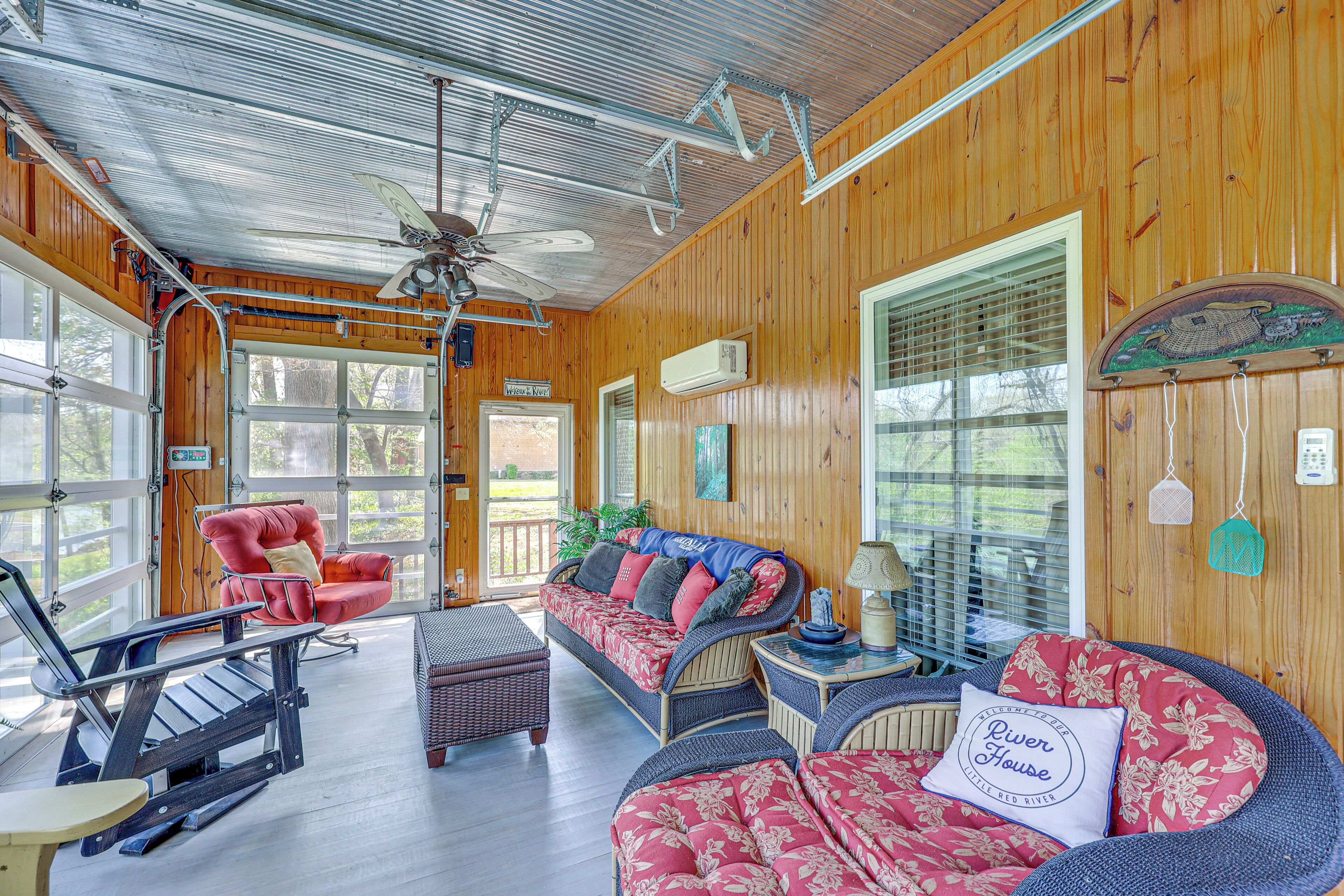 A wooden cabin interior with a sofa, chairs, and a rocking chair.