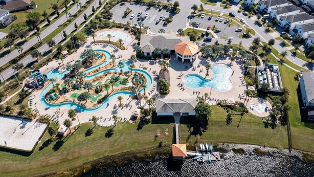 Ett flygbildsbild av ett bostadsområde med ett poolområde, inklusive en vattenrutschkana och ett separat poolområde.