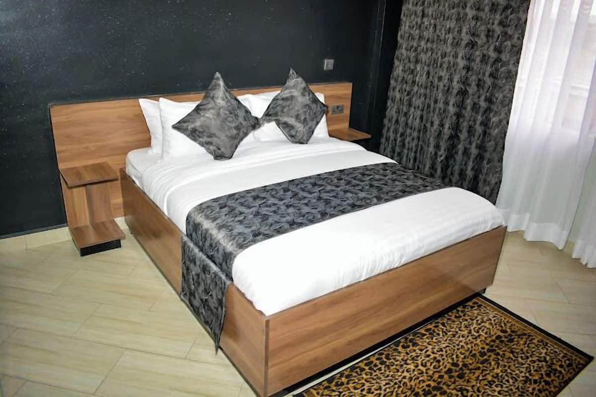 Ein modernes Schlafzimmer mit einem hölzernen Bett, zwei gleichfarbigen Kissen, einem Leopardenfellteppich und einem Nachttisch.