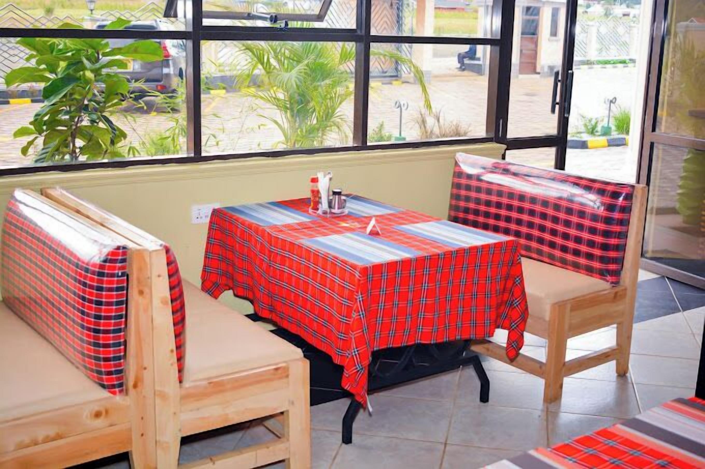 A restaurant with wooden booths and a red plaid tablecloth.