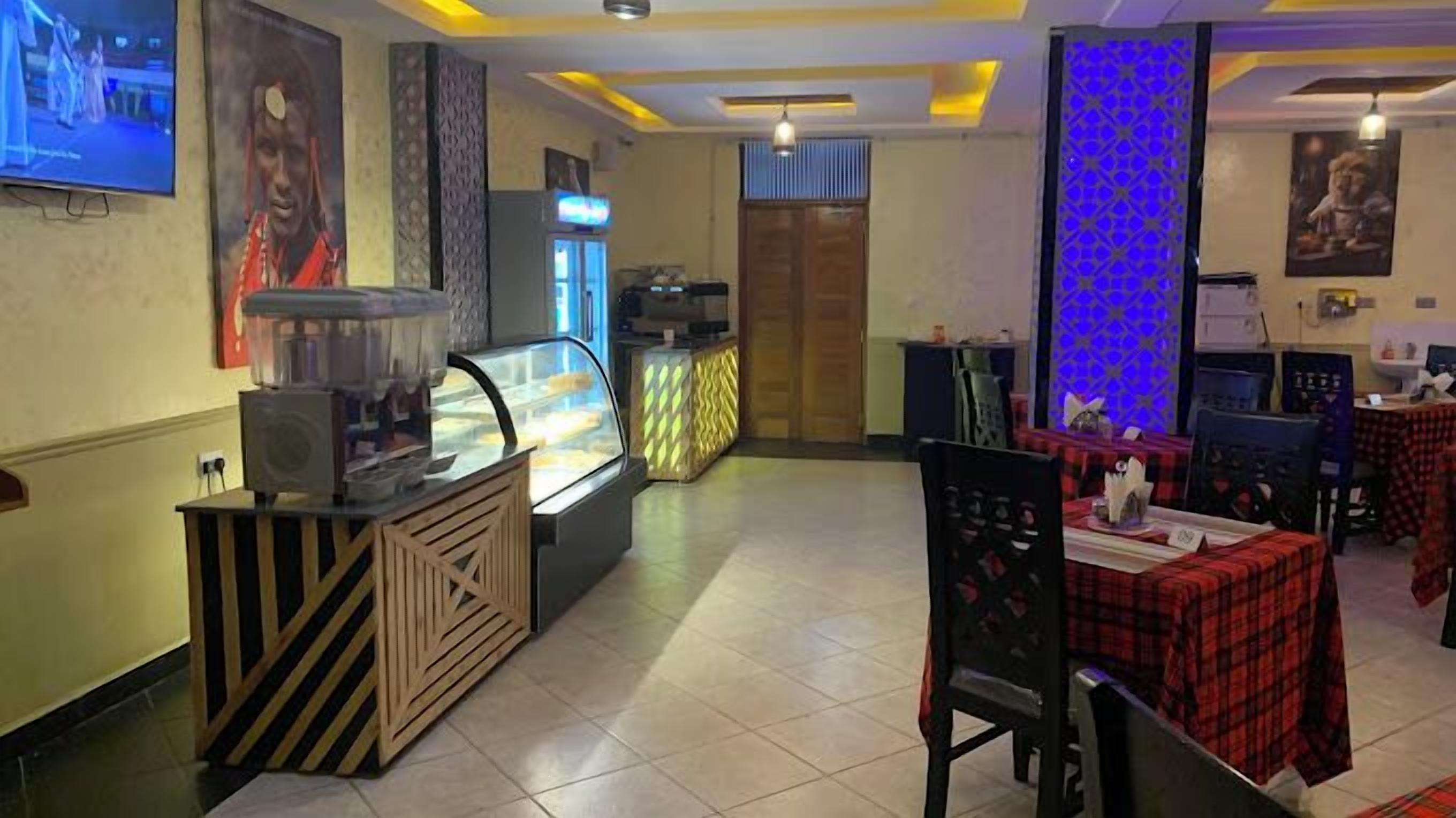 Ein Restaurant mit Theke, einer Vitrine und Tischen mit rot-schwarz karierten Tischdecken.