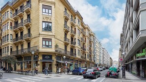 A street view of a building with multiple floors, balconies, and storefronts. - Izpizua II | The Rentals Collection (San Sebastián/Donostia)