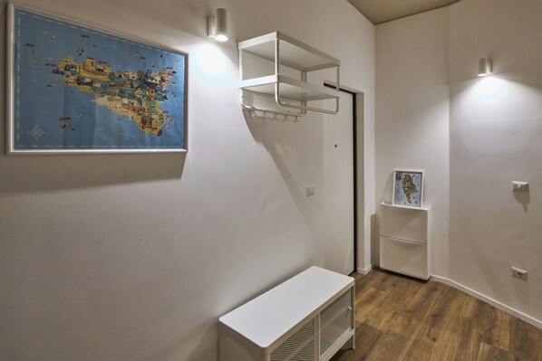 A room with a large map on the wall, a white shelf unit, and a white bench.